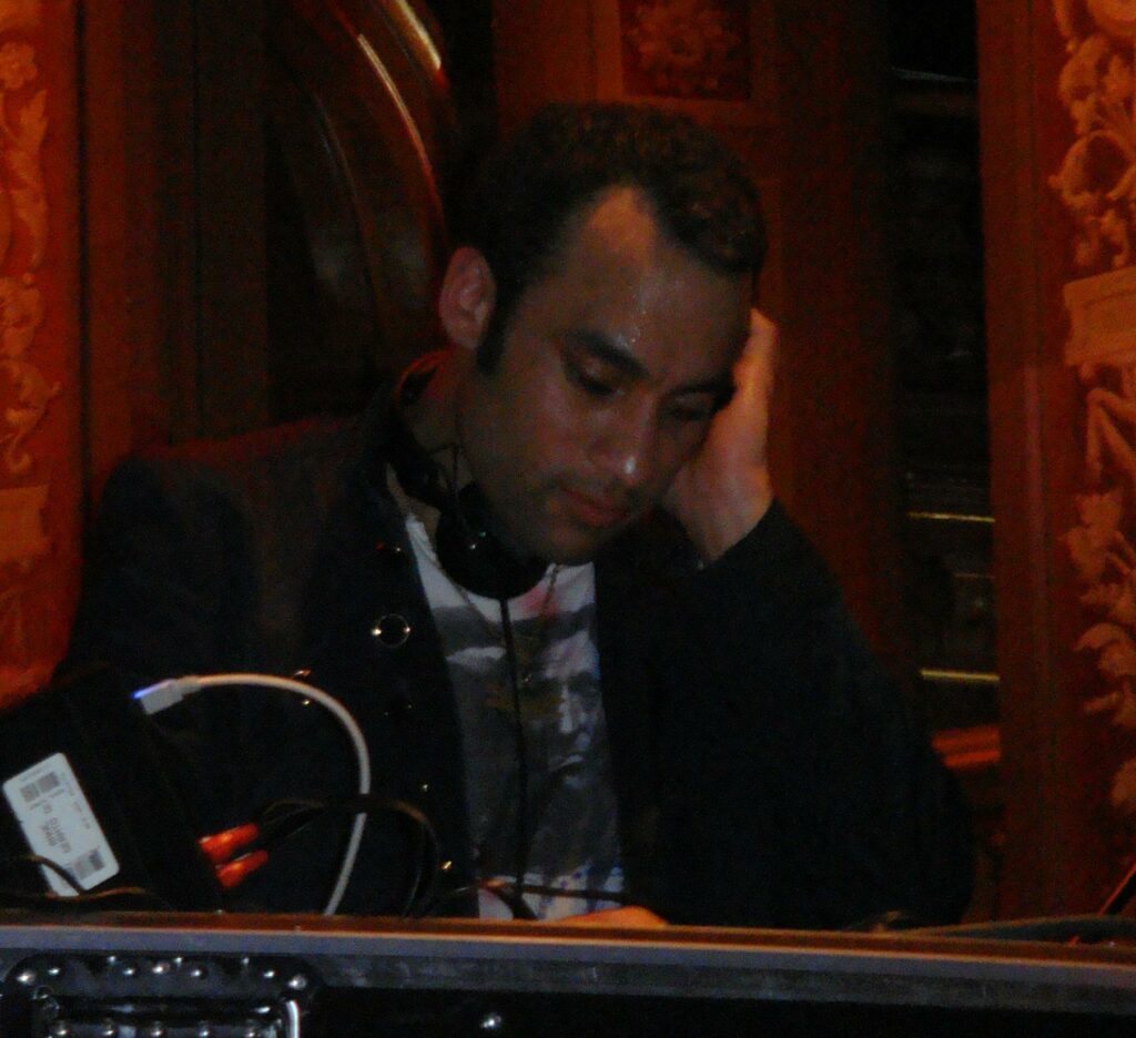 File:Stephen Simmonds DJing at Berns.jpg - a man in a suit and tie sitting at a table